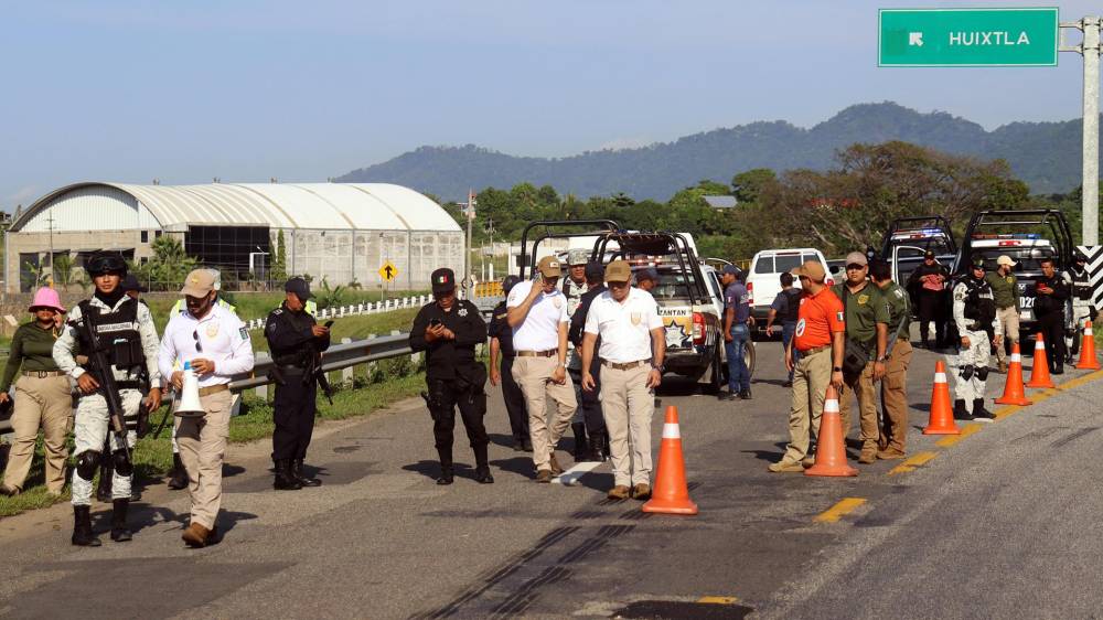 Personal del Instituto Nacional de Migración (INM) y de la Guardia Nacional (GN) bloquean una carretera ante el avance de una caravana de migrantes que caminan hacia la frontera con Estados Unidos.