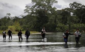 Foto de archivo de migrantes cruzando el río Tuquesa, luego de atravesar la selva de Darién.