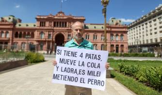 AME963. BUENOS AIRES (ARGENTINA), 17/02/2025.- Un hombre sostiene un cartel contra Javier Milei frente a la casa rosada este lunes, en Buenos Aires (Argentina).