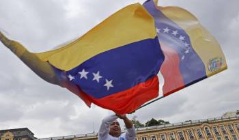 Fotografía de archivo en donde un hombre agita una bandera venezolana.