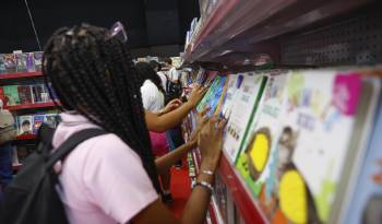 Una mujer observa un libro en la XX Feria Internacional del Libro en el Centro de Convenciones ATLAPA este 13 de agosto de 2024, en Ciudad de Panamá.