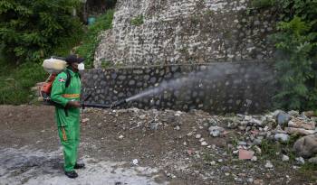 Un integrante de la Comisión Militar y Policial fumiga para eliminar criaderos del mosquito transmisor del dengue en Santo Domingo.