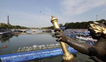 Atletas compiten en el triatlon masculino en el río Sena.