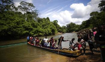 Fotografía de archivo de migrantes mientras descienden de una canoa antes de llegar a la Estación de Recepción Migratoria de Lajas Blancas luego de atravesar la selva del Darién.