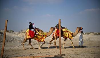 La gente monta en camello por las dunas del desierto de Al Wakrah, al sur de Doha, en una imagen de archivo.