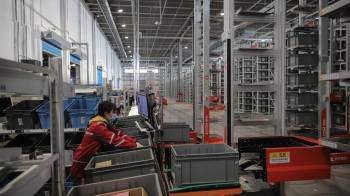 Fotografía de archivo de un trabajador en una unidad de transporte de contenedores en Pekín (China).