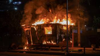 Fotografía de un módulo de la Policía Nacional Bolivariana (PNB) incendiado durante las protestas por los resultados de las elecciones presidenciales este lunes, en la autopista Prados del Este, en Caracas.