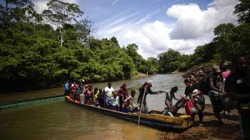 Fotografía de archivo de migrantes mientras descienden de una canoa antes de llegar a la Estación de Recepción Migratoria de Lajas Blancas, luego de atravesar la selva del Darién.