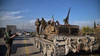 Fuerzas de seguridad sirias se encuentran sobre un tanque mientras participan en una operación tras los ataques realizados en su contra.