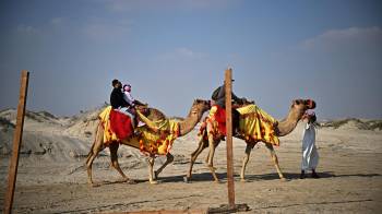 La gente monta en camello por las dunas del desierto de Al Wakrah, al sur de Doha, en una imagen de archivo.