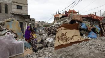 Una mujer palestina y un niño junto a una casa destruida en Rafah, en el sur de la Franja de Gaza, el 28 de enero de 2024.