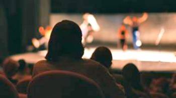 Una persona siendo espectador en una obra teatral.