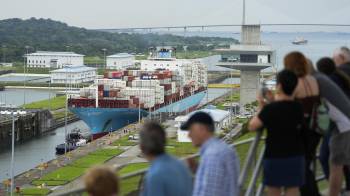 Turistas observan al carguero danés Lars Maersk navegando por las esclusas de Agua Clara del Canal, en la ciudad de Colón.