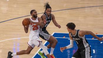 Mikal Bridges de los Knicks defiende un balón ante Devin Vassell de San Antonio Spurs durante un juego de la NBA.