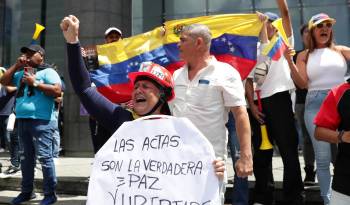 Una mujer sostiene un cartel este martes durante una protesta contra los resultados dados por el CNE, en Caracas.