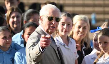 El rey Carlos III de Gran Bretaña hace un gesto frente a los escolares durante una visita a la Ópera de Sídney, en Sídney, el 22 de octubre de 2024.