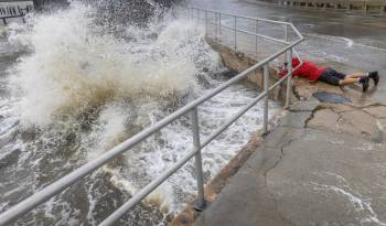 Un visitante desafía el fuerte oleaje, la marejada ciclónica y los fuertes vientos del huracán Helene para tomar fotografías en el centro de Cedar Key, Florida, EE. UU., El 26 de septiembre de 2024.