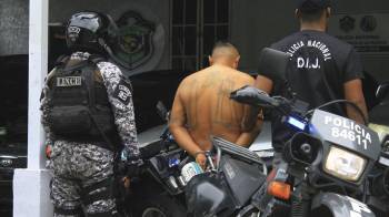 Fotografía tomada de la cuenta de la red social X de la Policía Nacional de Panamá que muestra a dos policías junto a un detenido salvadoreño este 11 de julio de 2024, en Ciudad de Panamá (Panamá).