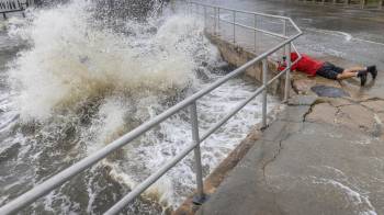 Un visitante desafía el fuerte oleaje, la marejada ciclónica y los fuertes vientos del huracán Helene para tomar fotografías en el centro de Cedar Key, Florida, EE. UU., El 26 de septiembre de 2024.