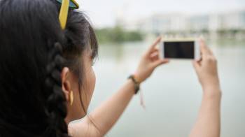 Young woman taking photo of the city, selective focus