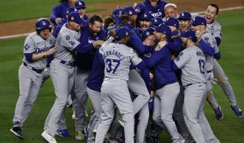 El pitcher de los Los Angeles Dodgers, Walker Buehler (C), es rodeado por sus compañeros de equipo para celebrar tras el último out contra los New York Yankees.