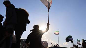 La gente se reúne para celebrar la toma de control de la oposición en Damasco, tras las oraciones del viernes, en la Plaza de los Omeyas en Damasco, Siria.