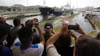 Fotografía de archivo de personas observando el paso de un barco por una sección de las esclusas Miraflores del Canal de Panamá.