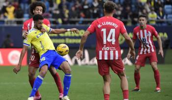 El centrocampista belga del Atlético de Madrid Axel Witsel (L) y el delantero español del Cádiz Chris Ramos compiten por el balón.