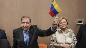 El líder opositor venezolano Edmundo González Urrutia sostiene una bandera de Venezuela a su llegada a un encuentro con ciudadanos venezolanos residentes en Guatemala este 15 de enero.