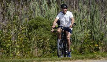 El presidente estadounidense Joe Biden pasea en bicicleta por el parque estatal Gordons Pond en Rehoboth Beach, Delaware, el 11 de agosto de 2024.