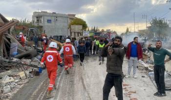 Rescatistas de la Cruz Roja Libanesa buscan víctimas y sobrevivientes en el lugar de un ataque aéreo israelí.