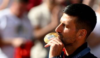 Novak Djokovic besa la presea de oro conseguida en París 2024.