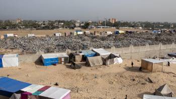 Desplazados palestinos viven en tiendas de campaña montadas junto a montañas de basura cerca de Jan Yunis, al sur de Gaza.