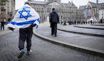 Un hombre que lleva una bandera israelí sobre sus hombros camina por la Plaza Dam en Ámsterdam, Países Bajos, el 8 de noviembre de 2024. EFE/EPA/Remko de Waal