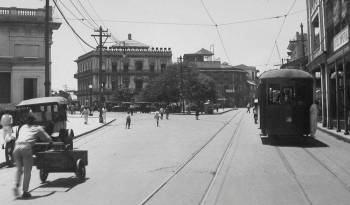 Avenida Central de la ciudad de Panamá cerca de la estación del Ferrocarril, Panamá 1924. Véase los distintos modos de transporte (peatones, tranvías, vehículos a motor y carruajes tirados por caballos) apostados sobre la estación de ferrocarril.