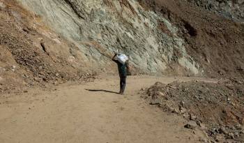 Fotografía de archivo en donde se ve a un joven cargando un saco de tierra con oro en una mina de Nicaragua.
