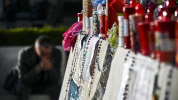 Un fiel reza frente a la estatua del papa Juan Pablo II en la entrada del Hospital Gemelli, donde está hospitalizado el papa Francisco, Roma.