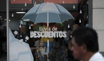 Un hombre camina junto a un local comercial en San José (Costa Rica.