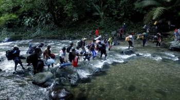 Fotografía de archivo que muestra a migrantes haitianos en su camino hacia Panamá por el tapón del Darién en Acandi, Colombia.