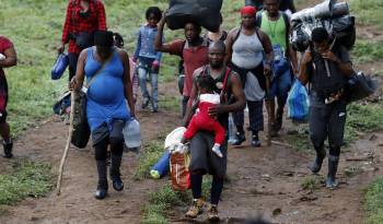 Fotografía de archivo fechada el 28 de septiembre de 2021 que muestra a migrantes haitianos en su camino hacia Panamá por el Tapón del Darién en Acandi.