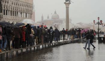 Imagen de Archivo de turistas al pasar por la pasarela colocada en la inundada plaza de San Marcos de Venecia.