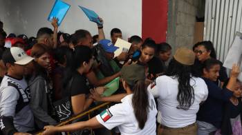 Migrantes hacen fila para tramitar papeles migratorios este viernes, en el municipio de Tapachula en Chiapas.