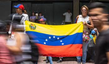 Dos mujeres sostienen una bandera de Venezuela durante una concentración convocada por la líder opositora María Corina Machado y el abanderaro de la oposición, Edmundo González Urrutia, en Caracas.