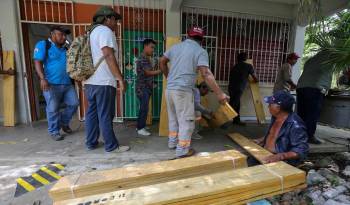 Habitantes del municipio de Felipe Carrillo Puerto refuerzan sus viviendas este jueves, en Quintana Roo.