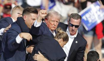 El expresidente estadounidense Donald Trump es sacado del escenario por el Servicio Secreto tras recibir un disparo en la oreja derecha.