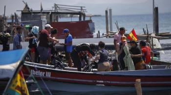 Migrantes venezolanos se suben a una embarcación en la isla Gardi Sugdub con destino a Colombia este martes, en la comarca Guna Yala.