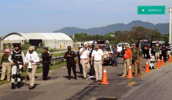 Personal del Instituto Nacional de Migración (INM) y de la Guardia Nacional (GN) bloquean una carretera ante el avance de una caravana de migrantes que caminan hacia la frontera con Estados Unidos.