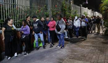Ciudadanos esperan en una fila para votar este domingo, en un centro de votación en Caracas, Venezuela.
