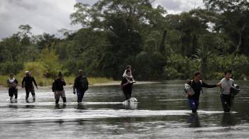 Fotografía de archivo en donde se ven migrantes que cruzan el río Tuquesa luego de atravesar la selva del Darién, frontera natural entre Colombia y Panamá.