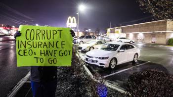 Una mujer, que no quiso ser identificada y que trabaja en la industria de la salud, sostiene un cartel de protesta frente al restaurante McDonald's donde el Departamento de Policía de Altoona arrestó a Luigi Mangione.